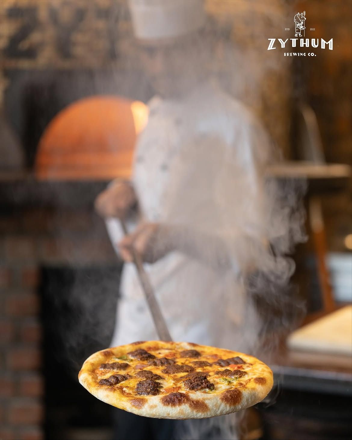 Pizza coming out of the wood-fired oven